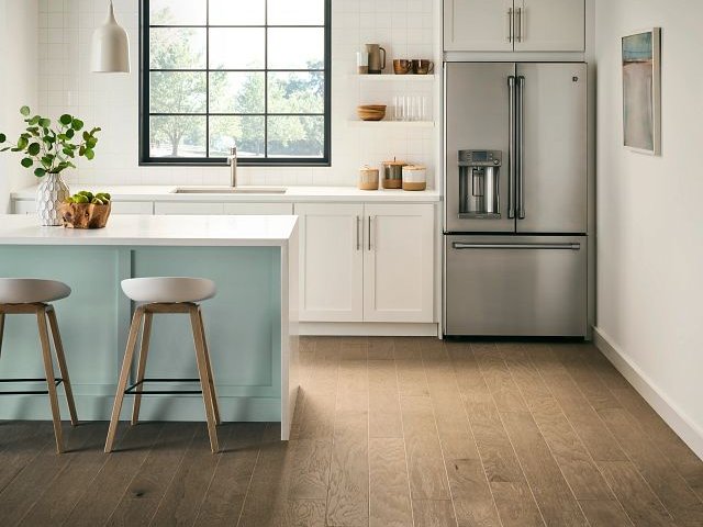 large modern kitchen with white bar top and bar stools